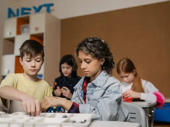 Teenagers assembling a robotics build together